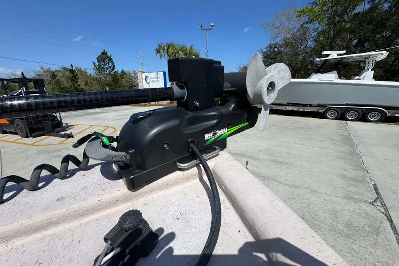 Slide: The Image of Trolling motor on a 2004 Kenner 21 VX boat, parked outdoors under clear skies. - 24