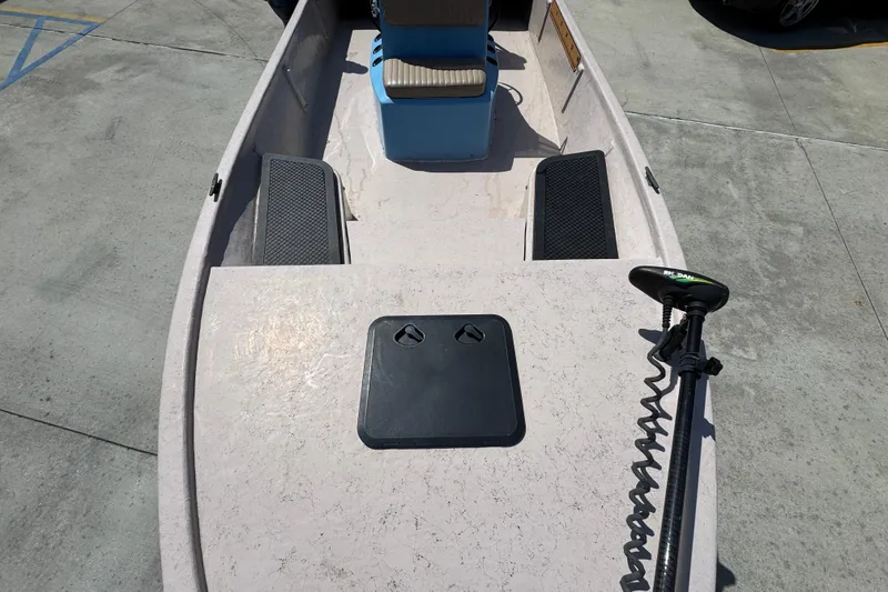 Slide: The Image of 2004 Kenner 21 VX boat interior with seating and trolling motor on concrete surface. - 25
