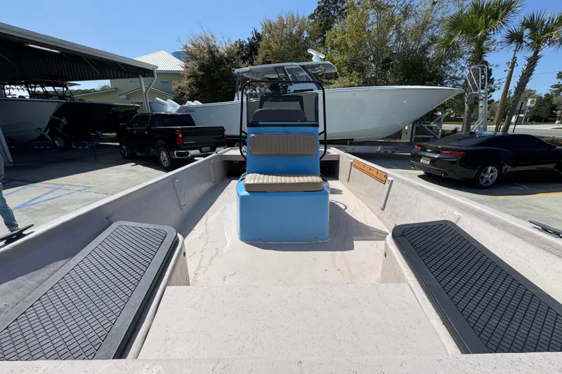 Slide: The Image of 2004 Kenner 21 VX boat interior with seating, parked near other vehicles. - 26