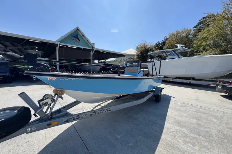 Slide: The Image of 2004 Kenner 21 VX boat on trailer, parked outdoors near other boats. - 3