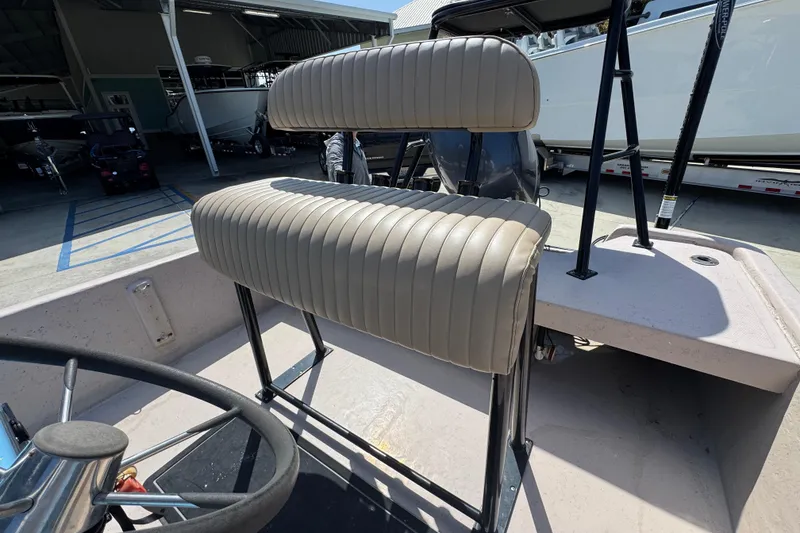 Slide: The Image of 2004 Kenner 21 VX boat interior with beige cushioned seating and steering wheel. - 30