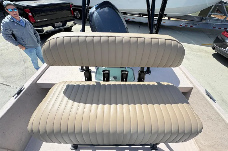 Slide: The Image of 2004 Kenner 21 VX boat with beige cushioned seating and a person smiling nearby. - 31