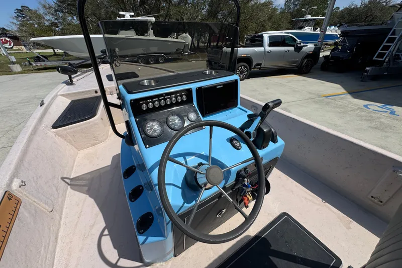 Slide: The Image of 2004 Kenner 21 VX boat dashboard with steering wheel and control panel. - 32