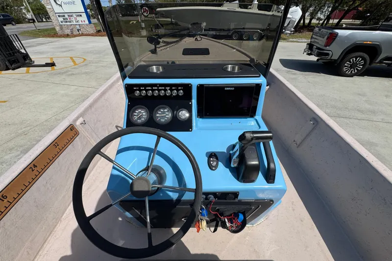 Slide: The Image of 2004 Kenner 21 VX boat dashboard with steering wheel and navigation controls. - 33