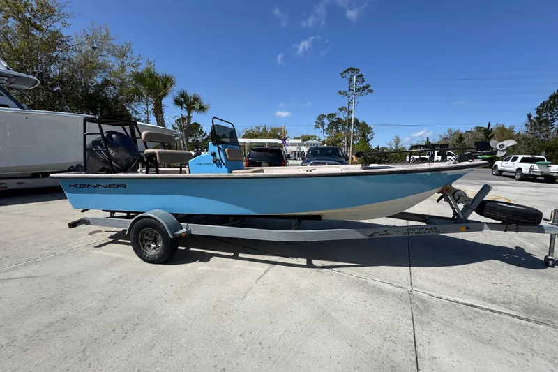 Slide: The Image of 2004 Kenner 21 VX boat on trailer, parked outdoors under clear blue sky. - 8
