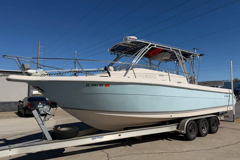 The Image of 2007 Cobia 312 Sport Cabin boat on trailer under clear blue sky. - 0