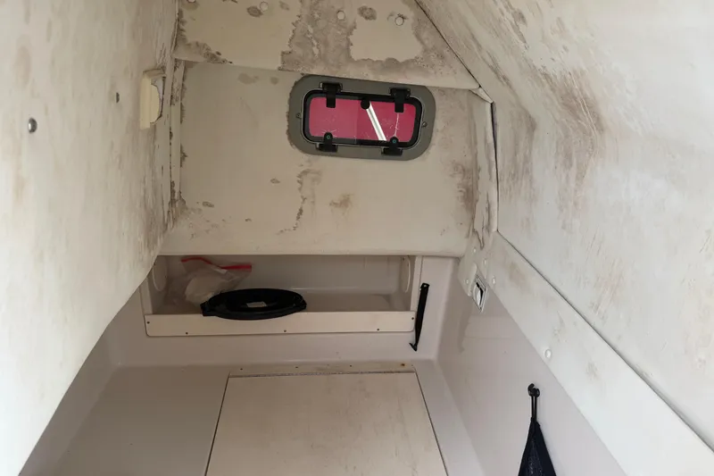 Slide: The Image of 2007 Cobia 312 Sport Cabin interior with small window and storage space. - 10