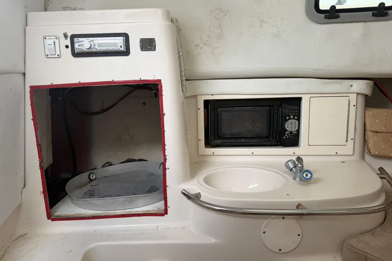 Slide: The Image of 2007 Cobia 312 Sport Cabin interior with microwave, sink, and storage space. - 12