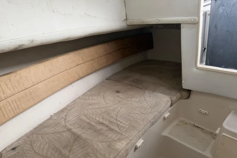 Slide: The Image of 2007 Cobia 312 Sport Cabin interior with cushioned sleeping area and storage space. - 16
