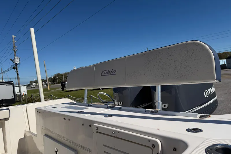 Slide: The Image of 2007 Cobia 312 Sport Cabin boat with Yamaha engines, parked outdoors under clear blue sky. - 21