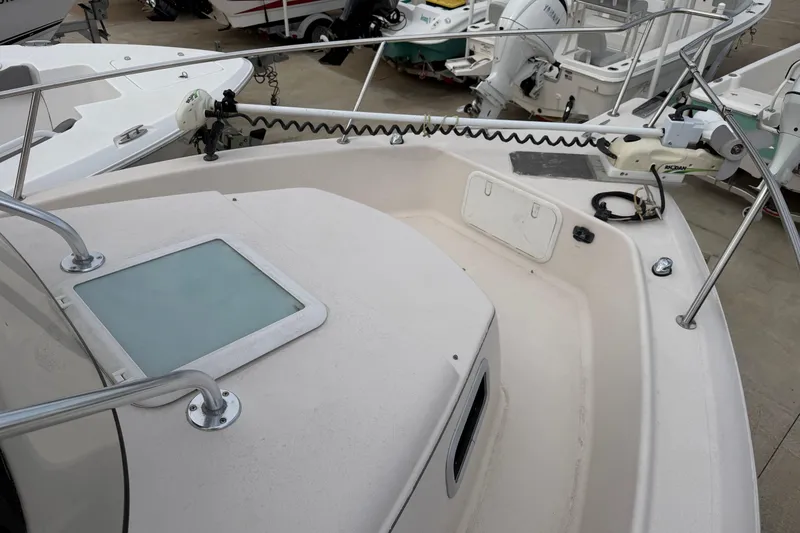 Slide: The Image of 2007 Cobia 312 Sport Cabin boat deck with railing and hatch, docked among other boats. - 4