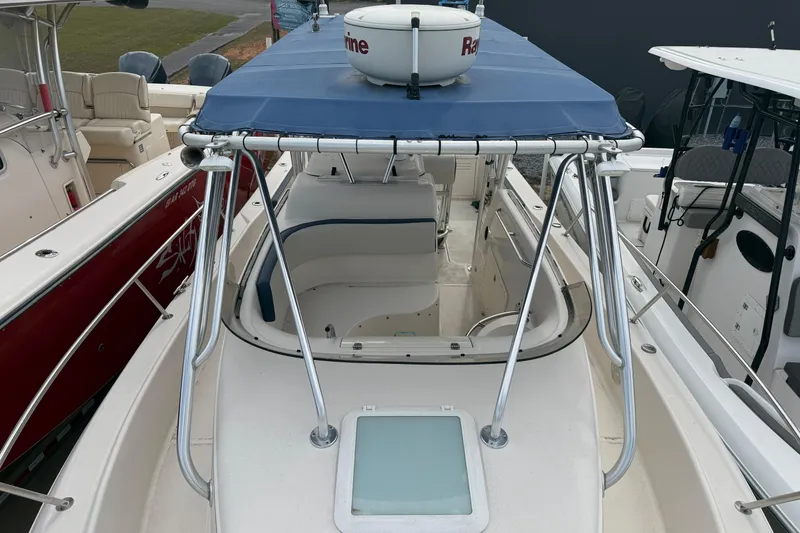 Slide: The Image of 2007 Cobia 312 Sport Cabin boat with blue canopy and spacious deck layout. - 5