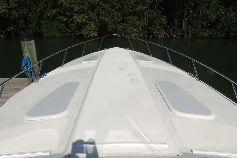 Slide: The Image of Bow view of a 2001 Formula 400 Super Sport boat docked near lush greenery. - 11