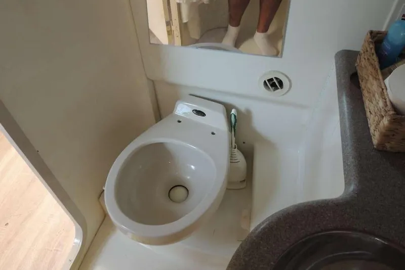 Slide: The Image of Compact bathroom in a 2001 Formula 400 Super Sport boat, featuring a toilet and sink. - 19