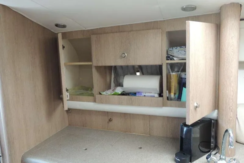 Slide: The Image of Interior of 2001 Formula 400 Super Sport with open wooden cabinets and countertop. - 27