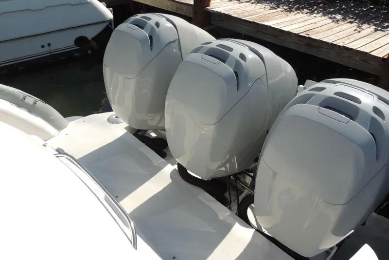 Slide: The Image of Triple outboard motors on a 2001 Formula 400 Super Sport boat docked. - 4