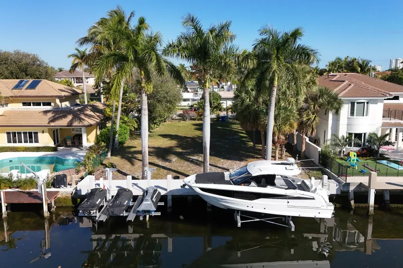 Slide: The Image of 2024 Galeon 325 GTO yacht docked by waterfront homes with palm trees. - 4