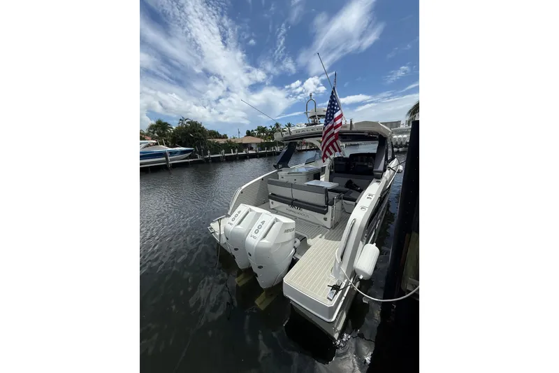 Slide: The Image of 2024 Galeon 325 GTO boat docked, featuring dual outboard engines and an American flag. - 5