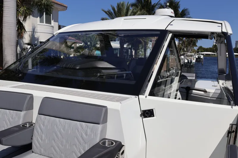 Slide: The Image of 2024 Galeon 325 GTO boat interior with gray seating and cup holder, docked by water. - 78