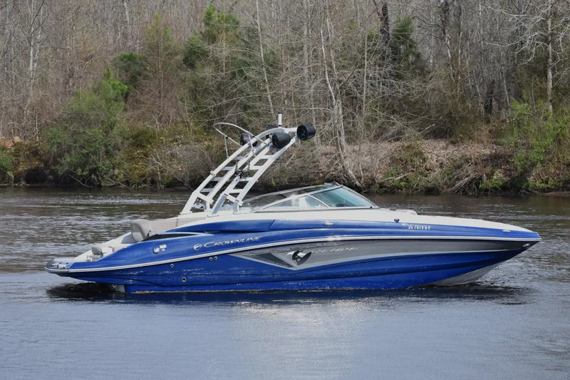 The Image of 2019 Crownline Eclipse E255 SURF boat on a calm river with forested background. - 0