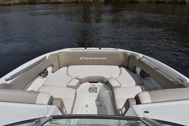 Slide: The Image of 2019 Crownline Eclipse E255 SURF boat interior with cushioned seating on calm water. - 6