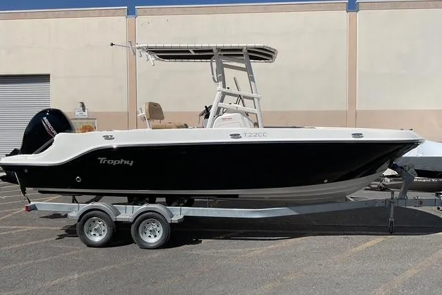 The Image of 2026 Bayliner Trophy T22CC boat on trailer, parked outdoors. - 0