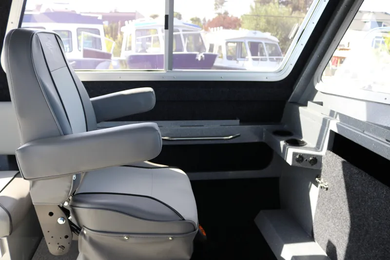 Slide: The Image of Interior of 2026 KingFisher 2825 Coastal Express boat with gray seating and window view. - 35