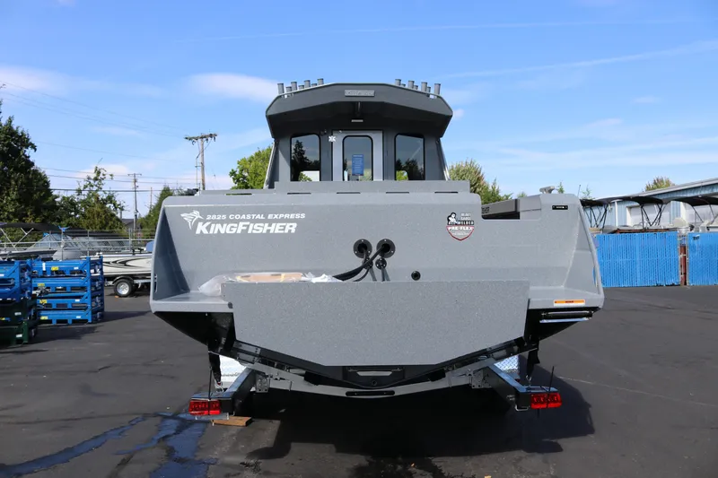 Slide: The Image of 2026 KingFisher 2825 Coastal Express boat, rear view, parked outdoors. - 5