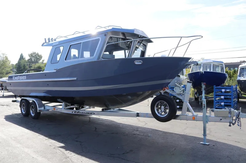 Slide: The Image of 2026 KingFisher 2825 Coastal Express boat on trailer, parked outdoors. - 6