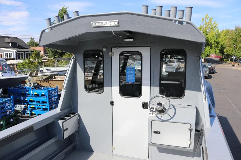 Slide: The Image of 2026 KingFisher 2825 Coastal Express boat with enclosed cabin and steering wheel. - 8