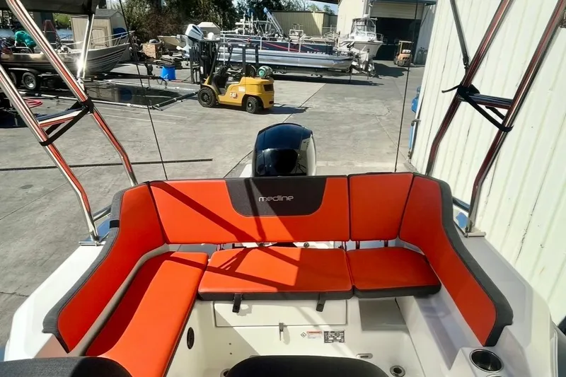 Slide: The Image of 2024 Zodiac Medline 6.8 boat with vibrant orange seating in a marina setting. - 10