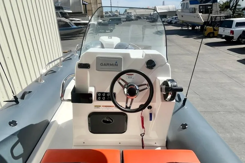 Slide: The Image of 2024 Zodiac Medline 6.8 boat dashboard with Garmin navigation system in a marina setting. - 11