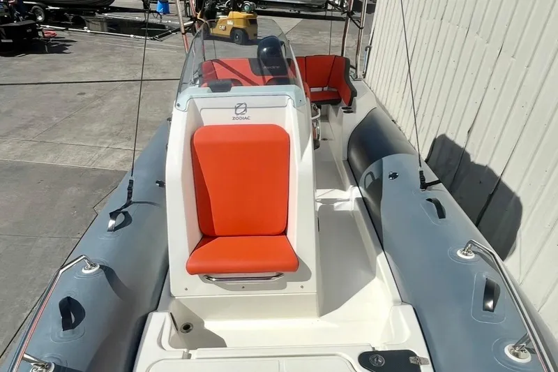 Slide: The Image of 2024 Zodiac Medline 6.8 boat with red seating, docked outdoors. - 14