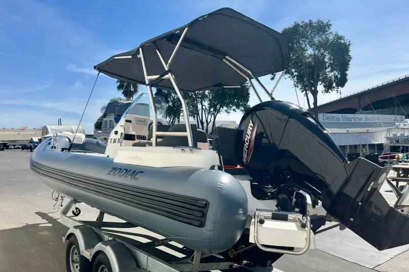 Slide: The Image of 2024 Zodiac Medline 6.8 boat with Mercury engine on trailer at marina. - 5
