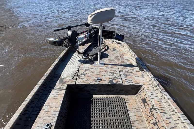 Slide: The Image of 2016 Express XP180 SC boat with camo deck, equipped for fishing on a lake. - 10
