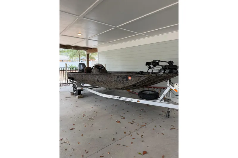 Slide: The Image of 2016 Express XP180 SC boat on trailer under covered area. - 11