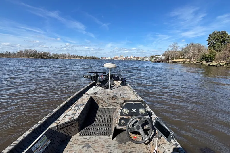 Slide: The Image of 2016 Express XP180 SC boat navigating a scenic river under a clear blue sky. - 6