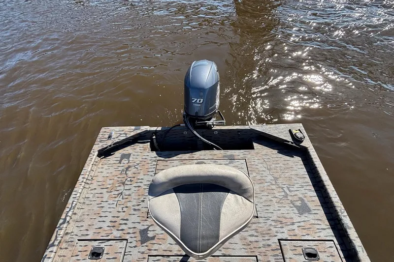 Slide: The Image of 2016 Express XP180 SC boat with motor on water, featuring camo deck and seat. - 8