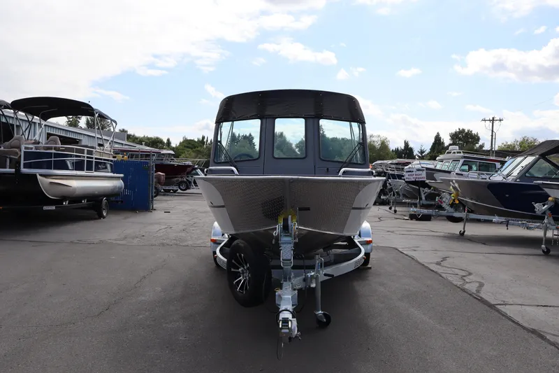 Slide: The Image of 2026 Alumaweld Intruder Outboard 20 boat on trailer in a marina parking lot. - 13