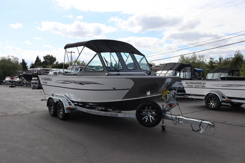 Slide: The Image of 2026 Alumaweld Intruder Outboard 20 boat on trailer, parked outdoors. - 14