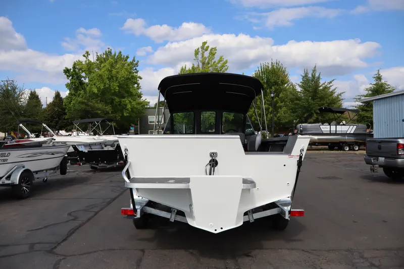 Slide: The Image of 2026 Alumaweld Intruder Outboard 20 boat, rear view, parked outdoors on a sunny day. - 3