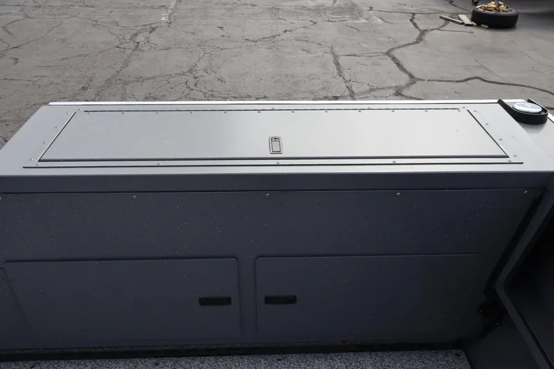Slide: The Image of 2026 Alumaweld Intruder Outboard 20 boat storage compartment on a textured surface. - 32