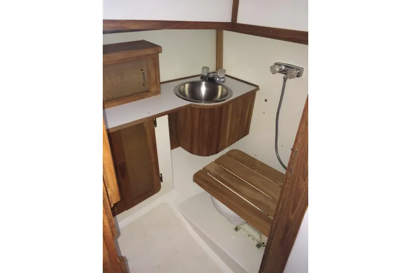 Slide: The Image of Compact 1997 Com Pac 27-2 boat bathroom with wooden cabinetry and stainless steel sink. - 4