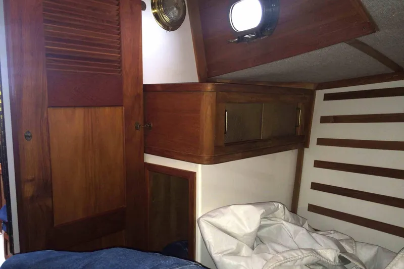 Slide: The Image of Interior of a 1997 Com Pac 27-2 sailboat with wooden cabinetry and porthole. - 6