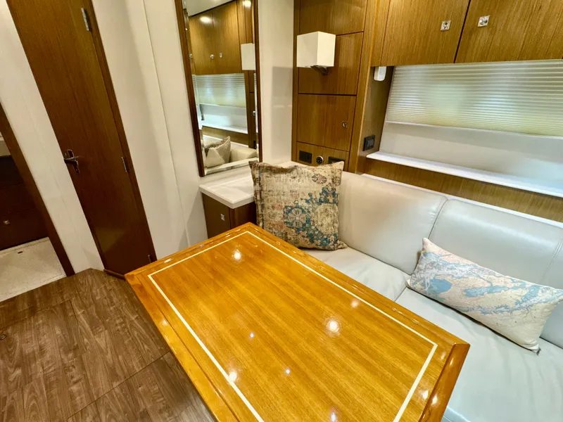 Slide: The Image of Interior of 2016 Cruisers Yachts 48 Cantius with wooden table and beige sofa. - 33