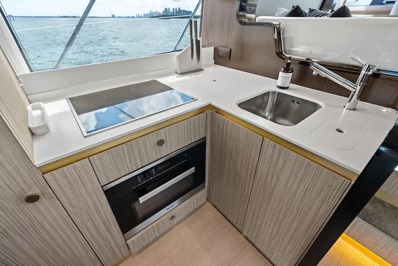 Slide: The Image of Modern yacht kitchen with sleek design, featuring stove, sink, and ocean view. Azimut, 2019. - 17