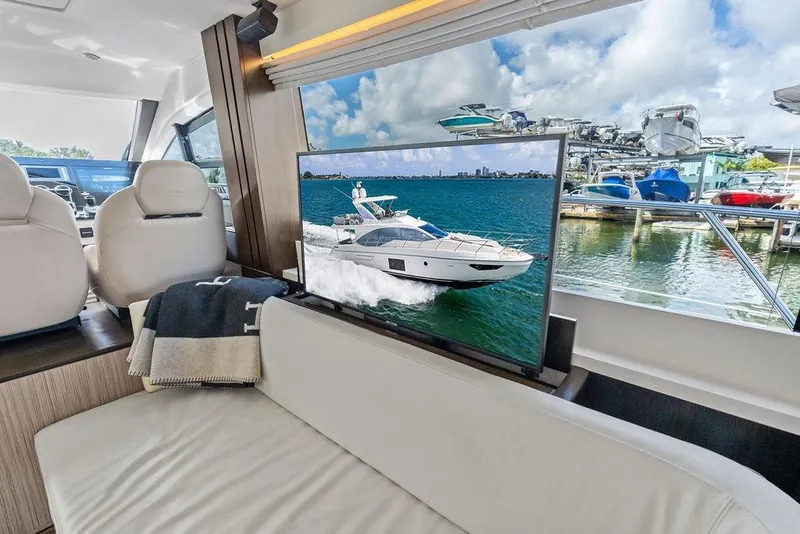 Slide: The Image of Interior of a 2019 Azimut yacht with a TV displaying a boat on water. - 21