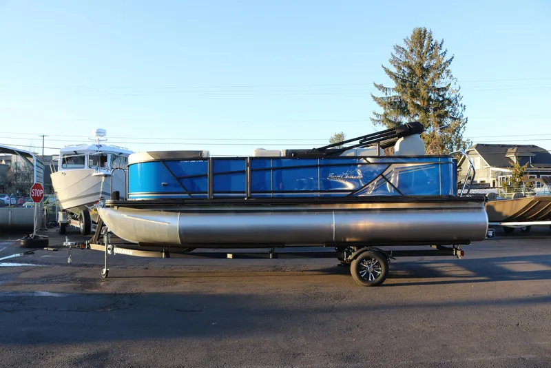 The Image of 2026 SunChaser Geneva Fish 22 pontoon boat on trailer, parked outdoors. - 0