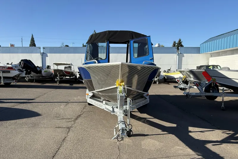 Slide: The Image of 2026 Alumaweld Intruder Outboard 22 boat on trailer in sunny outdoor setting. - 2