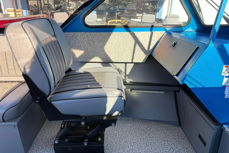 Slide: The Image of Interior of 2026 Alumaweld Intruder Outboard 22 boat with gray seating and blue accents. - 11